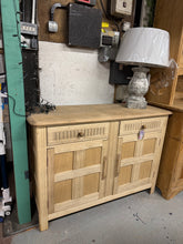 Load image into Gallery viewer, Authentic stripped oak sideboard restored to its natural finish. This characterful piece features two spacious drawers above a double cupboard, offering generous storage for any room. The bare wood shows gentle patina and minor surface marks that add to its vintage charm. A protective coat of wax is recommended to enhance and preserve the natural grain. Perfect for those seeking genuine, unfinished furniture with history.
Delivery Available
Overall Dimensions
121cm wide x 46cm deep x 87cm high\