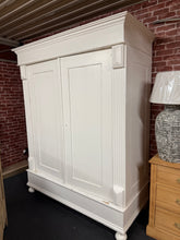 Load image into Gallery viewer, A beautifully characterful antique pine wardrobe with a painted finish. Structurally sound and in good overall condition, featuring the authentic patina and minor marks that speak to its age and history. The piece has been thoughtfully painted by previous owners, adding to its charm. Designed for practicality, this wardrobe completely dismantles for straightforward transport and repositioning. A hanging rail can be fitted if needed, offering flexibility to suit your storage needs. Perfect for adding wa