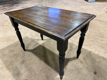 Load image into Gallery viewer, A charming wooden dining table with character and vintage appeal. Featuring distinctive black distressed legs and a solid structural foundation, this piece brings rustic warmth to any dining space. The tabletop shows warping , though when secured to the base, you may not notice too much.
Delivery Available
Overall Dimensions
110cm wide x 62cm deep x 74.5cm high
