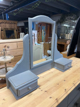 Load image into Gallery viewer, This sturdy dressing table mirror, crafted from solid pine, is in good overall condition. While it shows minor signs of use with a few small chips, nothing serious affects its charm. It also features two small drawers, perfect for handy storage.
Delivery Available
Overall Dimensions
90cm wide x 20cm deep x 66cm high 