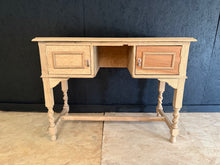 Load image into Gallery viewer, Authentic stripped oak desk returned to its natural finish. Structurally sound with minor surface marks that add character. Features two storage cupboards. May benefit from a protective wax coat to enhance and preserve the wood. Ready for finishing to your preference.
Delivery Available
Overall Dimensions
100cm wide x 46cm deep x 75.5cm high