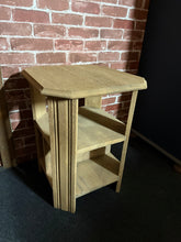 Load image into Gallery viewer, This oak side table combines practical storage with timeless appeal. Featuring two shelves for displaying books, plants, or decorative pieces, it offers genuine functionality in a compact footprint. The natural wood finish showcases the oak's character, though you may wish to apply wax for added protection and lustre. Built to last, this piece is structurally sound and ready to become a reliable addition to your home.
Delivery Available
Overall Dimensions
45cm wide x 46cm deep x 58.5cm high