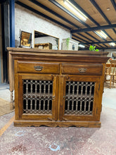 Load image into Gallery viewer, A characterful hardwood sideboard combining practical storage with timeless appeal. Two short drawers sit above a spacious double cupboard, offering flexible display and concealed storage solutions. Structurally sound with authentic patina from age and use—minor marks add to its vintage charm rather than detract from its quality. An ideal piece for those seeking genuine furniture with real-world character.
Delivery Available
Overall Dimensions
110cm wide x 46cm deep x 86cm high 