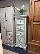 Load image into Gallery viewer, Charming shabby chic tallboy crafted from wood with distressed finish. Five dovetail-jointed drawers provide generous storage while maintaining the piece's vintage character. Structurally sound with minor cosmetic wear that adds to its rustic appeal. A statement piece perfect for bedrooms or living spaces seeking character and functionality.
Delivery Available
Overall Dimensions
57cm wide x 47cm deep x 141cm high