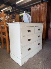 Load image into Gallery viewer, Discover the charm of authentic Victorian craftsmanship with this exquisite pine chest of drawers. Painted in soft white, the distressed finish reveals layers of history and character, showcasing genuine wear that only time can create. Built with traditional dovetail-jointed construction, it features two spacious long drawers and two smaller drawers above—ideal for bedroom storage or as a striking focal point in any room. A timeless statement piece that brings vintage elegance and practical storage to your
