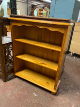 Load image into Gallery viewer, This sweet pine bookcase is structurally sound and in overall good condition. It is used and does have some marks but nothing too major. It has 2 shelves for storage.
Overall Dimensions
84cm wide x 28cm deep x 101cm high
DELIVERY AVAILABLE    
For our other items see our website https://fossewayfurniture.co.uk
collection from cv36 or bs36