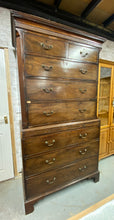Load image into Gallery viewer,  Discover the beauty and craftsmanship of this exquisite George III mahogany chest on chest. Adorned with a stunning moulded dentil cornice, it features two short and six long dovetail jointed drawers. Despite its age, it remains structurally sound and in good condition. Though there is some missing veneer, it does not detract from its overall appeal. Plus, it conveniently comes apart into two pieces for easy moving.