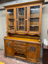 Load image into Gallery viewer, This stunning solid oak dresser is structurally sound and in overall good condition. It does have some marks and 1 missing handle , with another that requires TLC but otherwise nothing major. It offers ample storage with 2 cupboards and multiple shelves in the top section. The base section has 2 cupboards and 3 dovetail jointed drawers. It comes into 2 for easier moving.
Overall Dimensions
151cm wide x 45cm deep x 219cm high 
DELIVERY AVAILABLE    
HAVE THIS PAINTED A COLOUR OF YOUR CHOICE FOR AN EXTRA