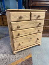 Load image into Gallery viewer, A characterful solid pine chest of drawers with vintage appeal. Featuring two short drawers over three generous long drawers, it offers practical storage with rustic charm. Structurally sound and in good overall condition with honest wear marks that add to its character. The natural pine finish suits country and farmhouse interiors beautifully. A light wax treatment will enhance the wood and provide added protection. An ideal piece for those seeking genuine vintage furniture with personality and functionali