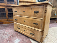 Load image into Gallery viewer, A charming period piece with genuine character, this antique pine chest of drawers combines solid construction with authentic vintage appeal. Featuring three spacious dovetail-jointed drawers, it offers reliable storage with the craftsmanship of a bygone era. While it bears the natural patina of age with minor surface marks and two replacement handles needed, these details only enhance its authentic charm. A wonderful addition for those who appreciate quality furniture with history and personality.
Overall