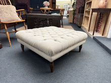 Load image into Gallery viewer, This versatile grey / beige upholstered pouffe could be used as a coffee table, offering flexible seating and surface space. Structurally sound and in good condition, it features a minor surface mark in the form of a small burn which could be easily concealed with a throw. An elegant accent piece that adapts to any living room layout.
Delivery Available
Overall Dimensions
88cm wide x 88cm deep x 37cm high