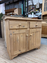 Load image into Gallery viewer, A charming stripped pine sideboard with authentic character. Features two short drawers positioned above a spacious double cupboard, offering practical storage for dining rooms or living spaces. The natural wood finish showcases the grain and patina of quality pine, though a protective wax coat is recommended to enhance durability. Structurally sound and well-maintained, this piece brings warmth and rustic appeal to country-style interiors and period homes.
Delivery Available
Overall Dimensions
91cm wide