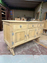 Load image into Gallery viewer, This beautiful stripped oak sideboard reveals authentic wood grain and character, ready for your finishing touch. A protective wax coat will enhance its natural patina and durability. Thoughtfully designed with three dovetail-jointed drawers above generous storage—one double and one single cupboard—offering ample space for dining essentials, linens, or display pieces. A versatile statement piece that brings warmth and timeless appeal to any room.
Delivery Available
Overall Dimensions
147cm wide x 49.5cm