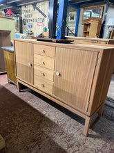 Load image into Gallery viewer, A distinctive mid-century teak sideboard with stripped finish, ready for your preferred protective wax or oil. Features two single cupboards and four dovetail-jointed drawers providing generous storage. Structurally sound and in excellent condition, this piece combines practical design with timeless style.

Delivery Available

Overall Dimensions

137cm wide x 49cm deep x 91.5cm + 3cm high\

