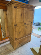 Load image into Gallery viewer, A charming solid wood wardrobe with authentic rustic character, featuring a spacious hanging rail and a beautifully crafted dovetail-jointed drawer for convenient storage. Well-loved and gently worn, this piece carries the natural patina of age with only minor marks that add to its vintage appeal. Designed for practicality, it separates into two sections for hassle-free transport and placement. Perfect for adding warmth and functionality to any bedroom.

Overall Dimensions

122cm wide x 65.5cm deep x 190.5c
