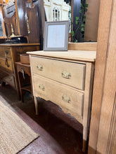 Load image into Gallery viewer, A charming oak chest of drawers, stripped to reveal its natural grain and warm patina. Features two spacious dovetail-jointed drawers offering generous storage. Structurally sound and in excellent condition. The bare wood finish showcases authentic character—a light wax coat will enhance protection and lustre.&nbsp;

Delivery Available

Overall Dimensions

76cm wide x 43cm deep x 77cm + 8cm high&nbsp;

