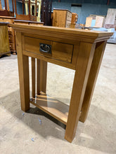 Load image into Gallery viewer, A charming oak side table with rustic appeal. Features a dovetail-jointed drawer and lower shelf, offering practical storage in a compact footprint. It has minor surface marks that speak to its history rather than detract from its appeal. An honest, well-made piece that brings warmth and functionality to any room.

Delivery Available

Overall Dimensions

60.5cm wide x 32cm deep x 75.6cm high
