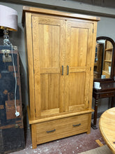 Load image into Gallery viewer, The Harrogate Rustic Solid Oak Double Wardrobe is a classic and durable storage solution, crafted from 100% solid oak with a deep rustic finish that enhances the natural wood grain.Designed for practicality and style, it features two doors opening to a spacious hanging area, perfect for organising clothes.Below, a wide dovetail jointed drawer on traditional wooden runners provides additional storage for accessories.Sturdy metal handles complete its timeless look, making it an ideal addition to any bedroom.B

