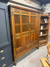 Load image into Gallery viewer, This Oriental Hardwood Cupboard combines practical storage with distinctive character. Built to last, it features a spacious interior with one shelf and two drawers, plus three dovetail-jointed drawers at the base for extra organisation. The piece shows honest signs of use with minor surface marks that add to its authentic appeal. A hanging rail can be installed if required, making it adaptable to your needs. A striking focal point for any room seeking vintage charm and functionality.&nbsp;

Delivery Availa

