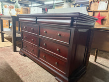 Load image into Gallery viewer, A well-crafted mahogany chest of drawers offering practical storage with six spacious long drawers plus two concealed compartments at the top. The piece shows honest signs of use with minor surface marks, but remains structurally solid and fully functional. Ideal for those seeking vintage style furniture with character and genuine storage capacity. This piece is originally from Oak Furniture Land.

Delivery Available

Overall Dimensions

137cm wide x 54cm deep x 86cm high

