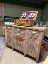 Load image into Gallery viewer, A striking satinwood sideboard with authentic character. Stripped to bare wood, revealing beautiful natural grain throughout. Structurally sound with ample storage—four generous drawers and three cupboards. The unfinished surface offers flexibility: keep the natural look or apply wax for added protection and patina. Surface shows minor marks consistent with vintage appeal. Perfect for those seeking statement-making storage with genuine craftsmanship.

Delivery Available

Overall Dimensions

135cm wide x 50c
