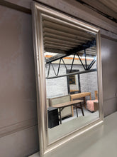 Load image into Gallery viewer, Brighten your space with this charming silver-framed mirror, complete with a lovely bevelled edge that adds classic elegance. Sturdy, this gently used mirror shows just the right amount of patina—proof of its enduring quality.&nbsp;

Delivery Available

Overall Dimensions

91cm x 116.5cm&nbsp; &nbsp; &nbsp; &nbsp;&nbsp;

