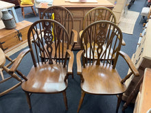 Load image into Gallery viewer, A charming set of four oak wheelback carver chairs, each structurally sound and ready for everyday use. These vintage pieces showcase authentic character with their traditional wheelback design. While showing natural signs of age and use, they remain in good overall condition with only minor surface marks. Perfect for adding period charm to a dining space or period home.

Delivery Available

Overall Dimensions

approx : 57cm wide x 50cm deep x 96cm high / 45.5cm seat height&nbsp;

