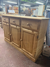 Load image into Gallery viewer, This beautiful stripped pine sideboard showcases the wood's natural grain and character. Completely bare and ready for finishing, it's the perfect canvas for wax, oil, or paint to suit your décor. Practical storage includes three drawers above a double cupboard and single cupboard, offering generous space for dining room essentials. Structurally sound and in good overall condition, it's a versatile piece that works equally well in traditional or contemporary settings.

Delivery Available

Overall Dimensions
