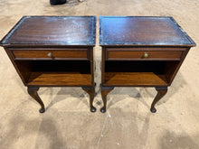 Load image into Gallery viewer, A pair of mahogany bedside tables offering practical storage with one drawer and lower shelf per unit. Both pieces are structurally solid and in good working order, though showing natural signs of age with minor surface marks. Each table features a protective glass top. Ideal for adding warmth and character to a bedroom whilst maintaining functionality.

Delivery Available

Overall Dimensions

46cm wide x 33cm deep x 63.5cm high
