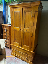 Load image into Gallery viewer, A characterful solid pine wardrobe combining practical storage with vintage charm. Features one hanging rail for garments, two dovetail-jointed drawers for smaller items, and an internal mirror. The piece shows honest wear consistent with its age—minor marks add to its authentic appeal. Disassembles into three sections for convenient transport and placement. Structurally sound and ready for use.

Delivery Available

Overall Dimensions

96cm wide x 59cm deep x 182cm high


