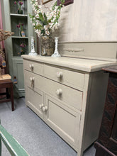 Load image into Gallery viewer, A charming painted oak sideboard in soft beige-grey with subtle distressing. Features practical storage across two short dovetail-jointed drawers, one long drawer, and a spacious double cupboard—ideal for dining rooms or living spaces. Structurally sound and in excellent condition, this piece combines vintage character with everyday functionality.

Delivery Available

Overall Dimensions

113cm wide x 45cm deep x 81cm + 19cm high


