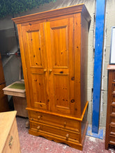 Load image into Gallery viewer, A spacious solid pine wardrobe in structurally sound condition. Features a hanging rail for garments and two deep dovetail-jointed drawers offering ample storage. The piece shows minor cosmetic marks consistent with age and use, but remains in good overall condition. Designed to disassemble into two sections for convenient transport and placement.

Delivery Available

Overall Dimensions

96cm wide x 59cm deep x 182cm high

