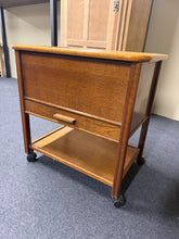 Load image into Gallery viewer, A charming oak sewing box with solid construction and practical storage solutions. The hinged lid opens to reveal generous space, whilst a single drawer and lower shelf provide additional organisation for your supplies. The piece shows its age with minor surface marks, but remains in sound working condition.

Delivery Available

Overall Dimensions

62.5cm wide x 43.5cm deep x 62cm high&nbsp;

