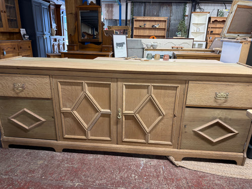 This charming large oak sideboard has been returned to its natural finish and could shine even more with a coat of wax. It offers ample storage with two drawers, one double cupboard, and two single cupboards. Being a used piece, it shows some signs of wear like missing trim and a small bit of wood beneath one drawer, which only enhance its character and appeal.

Overall Dimensions

229cm wide x 52cm deep x 85cm high

DELIVERY AVAILABLE      

For our other items see our website https://fossewayfurniture.co.