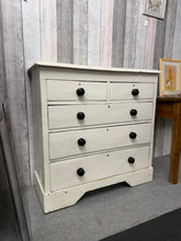 Load image into Gallery viewer, A characterful vintage wooden chest of drawers with authentic period appeal. Structurally sound and in good working order, featuring two short dovetail-jointed drawers above three longer ones. The distressed paintwork and visible wear marks are testament to its age and add genuine vintage character. Perfect for those who appreciate authentic, lived-in furniture with history.

Delivery Available

Overall Dimensions

102cm wide x 43cm deep x 101cm high

