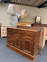 Load image into Gallery viewer, Crafted from solid pine, this sideboard combines practical storage with timeless appeal. Two dovetail-jointed drawers sit above a double and single cupboard, offering flexible space for dining room essentials or living room display. Built to last, it shows marks consistent with use—a few minor ones that add character without compromising function or structure.

Delivery Available

Overall Dimensions

122cm wide x 42.5cm deep x 86cm high

