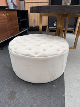 Load image into Gallery viewer, A versatile grey / cream upholstered pouffe featuring a classic buttoned top design. Structurally sound and in good condition, with minor surface marks that can be easily cleaned. Perfect for adding extra seating or footrest to any bedroom or living room. Complements both traditional and contemporary interiors with its neutral colour palette and timeless style.

Delivery Available

Overall Dimensions

80cm diameter x 40cm high

