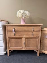 Load image into Gallery viewer, Discover the charm of this Stripped Oak Cupboard, a structurally sound piece in excellent condition. Completely stripped back to reveal beautiful natural wood grain, it's ready for your finishing touch—a protective coat of wax will enhance its character. Features two spacious dovetail-jointed drawers positioned above a generous double cupboard, offering ample storage for any room.&nbsp;

Delivery Available

Overall Dimensions

97cm wide x 47cm deep x 91.5cm high

