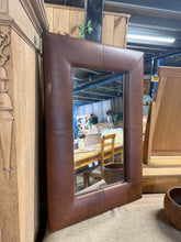Load image into Gallery viewer, An NEXT leather effect mirror in solid, working condition. Shows gentle signs of use with minor surface marks consistent with pre-loved furnishings. Structurally sound and ready to add character to any interior.

Delivery Available

Overall Dimensions

60cm wide x 90cm high

