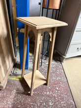 Load image into Gallery viewer, A charming oak plant stand with authentic character. Stripped back to reveal natural wood grain, this sturdy piece is structurally sound and ready to display your favourite plants. The lower shelf provides practical storage space. A protective coat of wax will enhance the finish and durability. Perfect for adding warmth to any room.

Delivery Available

Overall Dimensions

27cm wide x 27cm deep x 69cm high


