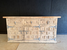 Load image into Gallery viewer, This authentic Spanish sideboard showcases beautiful natural wood grain after being stripped back to bare timber. The piece features three dovetail-jointed drawers positioned above three spacious cupboards, offering generous storage for any room. Structurally sound and in excellent condition, it may benefit from a protective coat of wax to enhance and preserve the wood finish. A versatile statement piece that brings character and functionality to traditional or eclectic interiors.

Delivery Available

Overa
