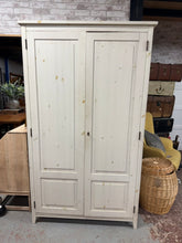 Load image into Gallery viewer, A spacious double pine wardrobe offering practical storage solutions for any bedroom. This pre-loved piece features solid construction with one hanging rail and a shelf, providing flexible organisation for clothes and accessories. While showing natural signs of use with minor surface marks, the wardrobe remains in sound working condition and ready for everyday use. Comes complete with key.

Delivery Available

Overall Dimensions

114cm wide x 61cm deep x 196cm high

