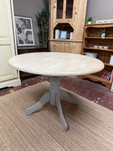 Load image into Gallery viewer, Charming whitewashed pine round dining table with grey painted legs. Features a rustic finish with character marks that add to its vintage appeal. Seats four comfortably and disassembles for convenient transport. Ideal for smaller dining spaces or cosy kitchen gatherings. Some areas may benefit from light refinishing to restore the original lustre.

Delivery Available

Overall Dimensions

108cm diameter x 74cm high

