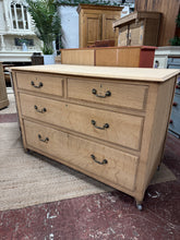 Load image into Gallery viewer, A beautiful stripped oak chest offering authentic character and versatility. Four dovetail-jointed drawers—two shallow, two deep—provide generous storage for any room. The natural wood finish showcases the grain and patina, ready for your own wax treatment to enhance protection and lustre. Castors make repositioning effortless. Ideal for those who appreciate reclaimed furniture with genuine craftsmanship.

Delivery Available

Overall Dimensions

114.5cm wide x 52cm deep x 79cm high

