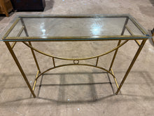 Load image into Gallery viewer, A striking console table featuring a gleaming gold-toned metal frame paired with a practical glass top that lifts away for easy cleaning. While this piece shows its character through minor surface marks, the structure remains solid and reliable. Perfect for adding elegance to an entryway or living space without compromising on functionality.

Delivery Available

Overall Dimensions

105cm wide x 45cm deep x 90cm high

