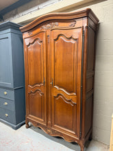 Load image into Gallery viewer, A stunning cherry wood armoire in excellent condition, featuring four adjustable shelves for flexible storage solutions. The piece is structurally sound with only minor cosmetic marks that add to its character. The cornice removes easily for transport, whilst the main body remains intact. An additional shelf is included but requires one bracket to be fitted. Comes with two original keys, making it ideal as a linen press, larder, or clothing storage. A versatile and elegant addition to any home.

Delivery Av
