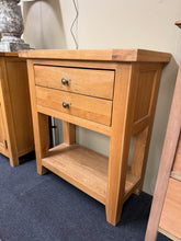 Load image into Gallery viewer, This characterful oak hall table combines practical storage with timeless appeal. Featuring two dovetail-jointed drawers and a lower shelf, it offers generous space for hallway essentials. The solid construction remains fully functional, with only minor cosmetic marks that add to its authentic vintage charm. Screw holes can be easily concealed with larger handles to refresh the look. An ideal piece for adding warmth and storage to any entrance.

Delivery Available

Overall Dimensions

75cm wide x 37cm deep 
