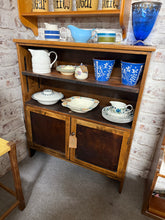 Load image into Gallery viewer, This charming oak mid-century display cabinet from the 1940s/1950s is sturdy and well-preserved. While it shows some signs of use, the marks are minor. It offers plenty of storage space, featuring one double cupboard and a single shelf.

Delivery Available

Overall Dimensions

94cm wide x 27cm deep x 107cm high&nbsp; &nbsp; &nbsp;


