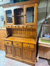 Load image into Gallery viewer, A sturdy solid pine dresser in good working condition with only minor cosmetic marks. Disassembles into two sections for convenient transport and setup. Features generous storage across two cupboards, four small dovetail-jointed drawers at the top, three larger dovetail-jointed drawers in the middle, plus one double and one single cupboard below. Ideal for dining or living spaces needing substantial, durable storage.

Delivery Available

Overall Dimensions

125cm wide x 49cm deep x 197cm high&nbsp;

