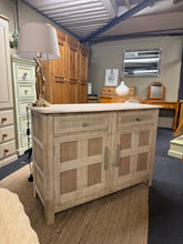Load image into Gallery viewer, A beautiful stripped oak sideboard in its natural state, revealing the wood's authentic character and grain. This versatile piece features two spacious drawers above a generous double cupboard, offering ample storage for your living room or dining area.
The piece shows patina consistent with vintage furniture and benefits from a protective wax coat to enhance and preserve the finish. Structurally sound and ready to bring warmth and timeless style to your home.

Delivery Available

Overall Dimensions

122cm 

